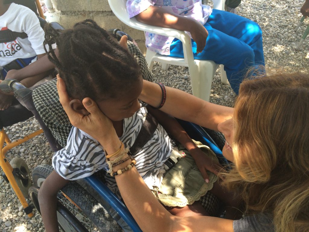 Pamela Mary Schmidt in Haiti and a child in a wheelchair